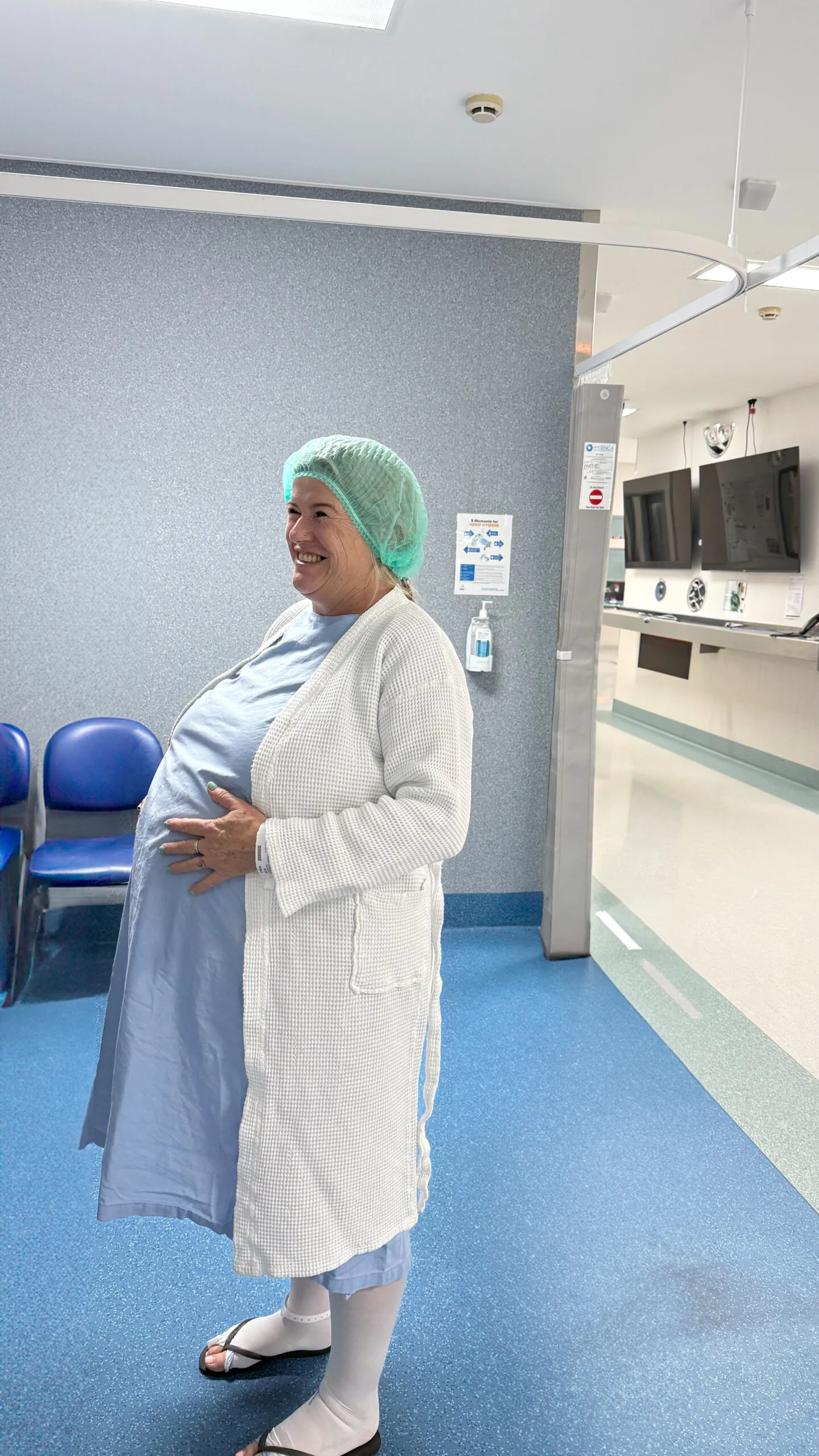 A heavily pregnant woman wearing a hospital gown