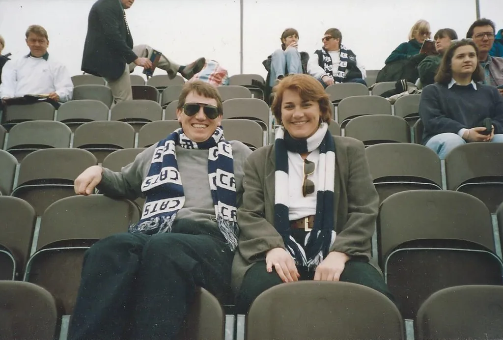 Image of sister and brother watching a football game