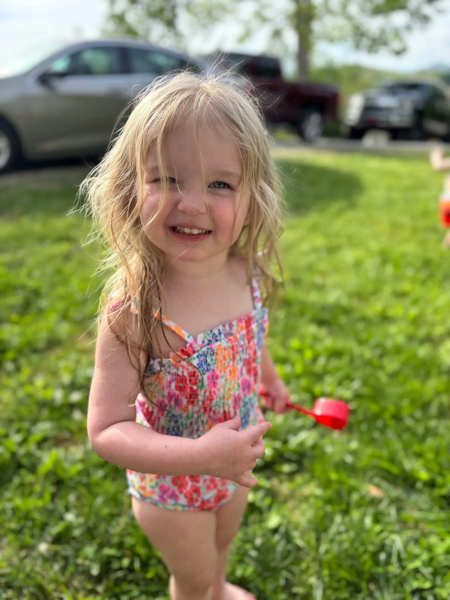 A young girl wearing a swimming costume playing in the grass