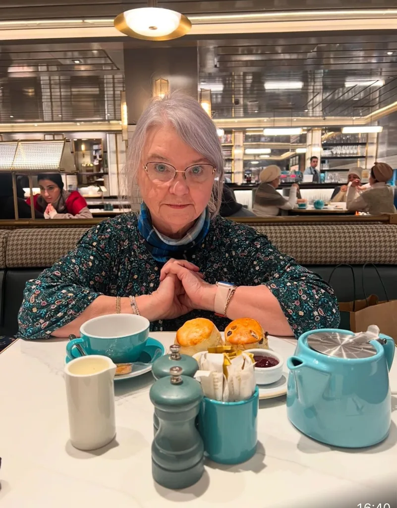 Image of woman sitting down for a cup of tea and scone