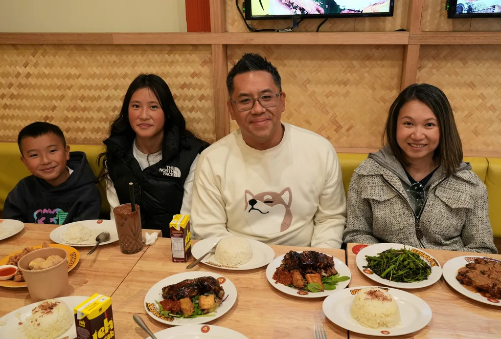 A family of four shairng a meal at a restaurant.