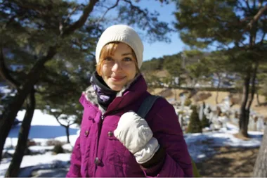 Liz in a pink parker, white beanie and gloves