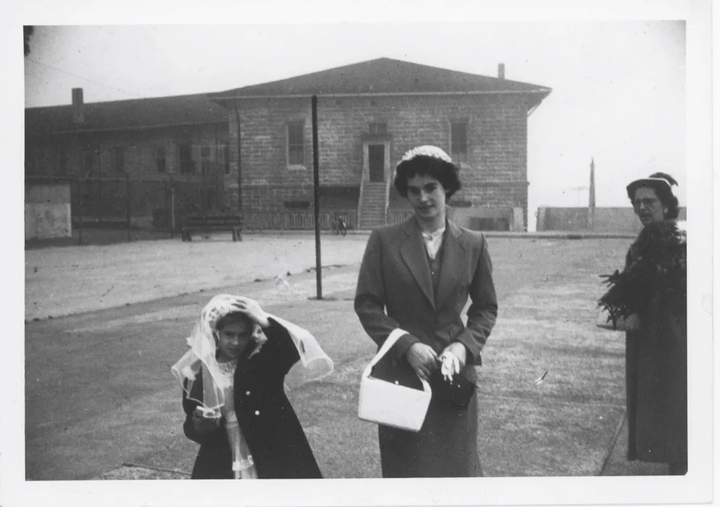 two girl sand woman in black and white photo stood outside