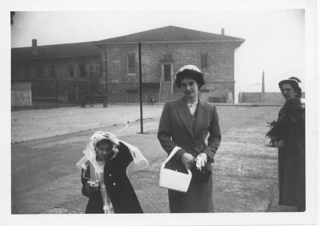 two girl sand woman in black and white photo stood outside