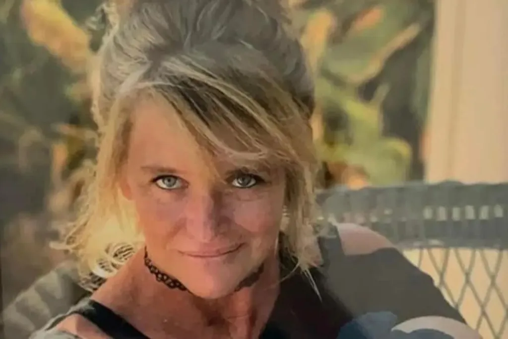 An old photo of Angela Prichard, she has dark eyeliner, a blonde updo and goth style choker necklace