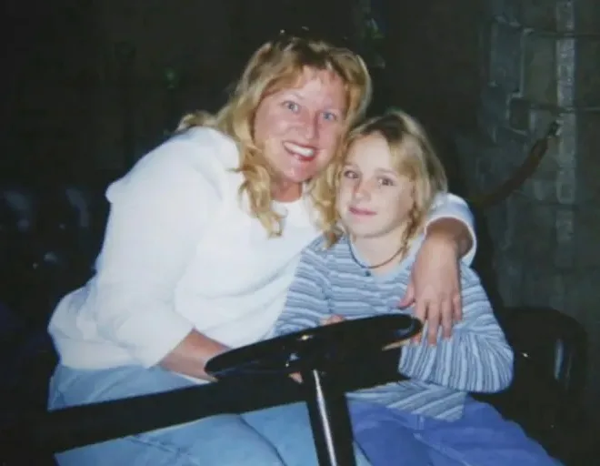 woman in white and girl in blue holding a wheel