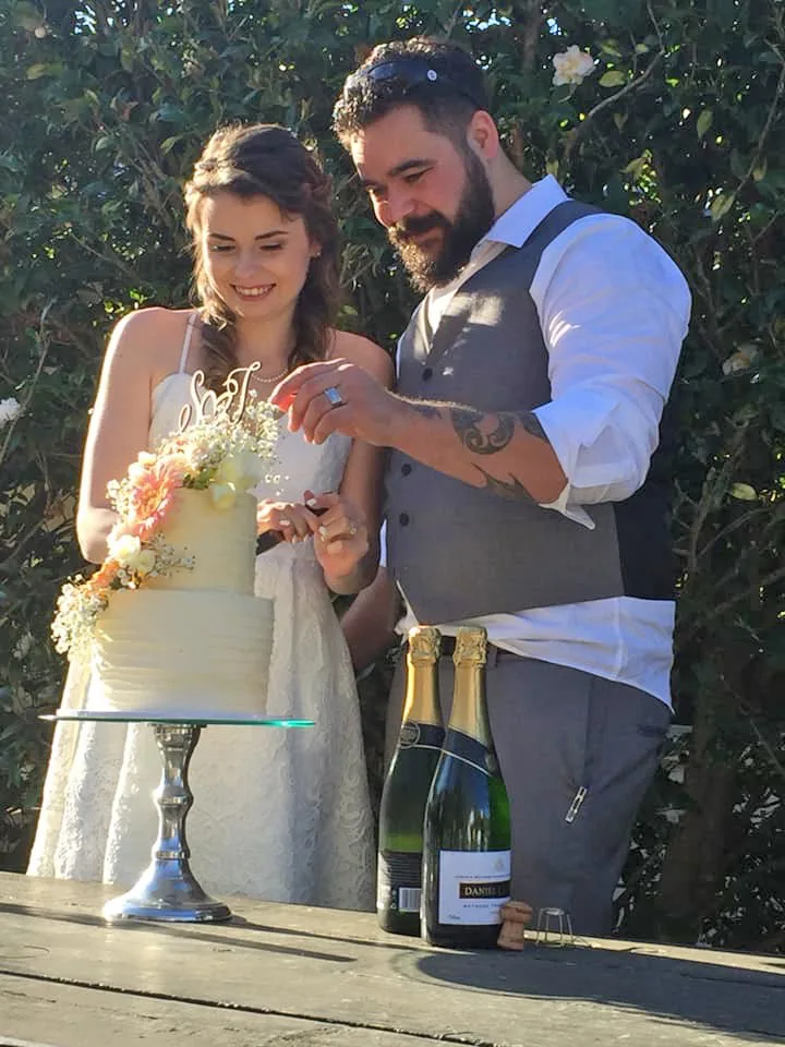 A bride and groom cut cake on their wedding day