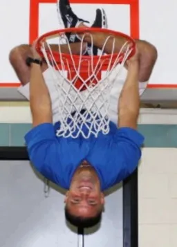 a man upside down on a basketball ring