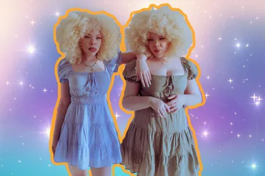 Megan and her identical twin sister Mikayla wearing dresses and posing for the camera. Their images are against a sparkly purple and blue background and there's an orange outline around them.