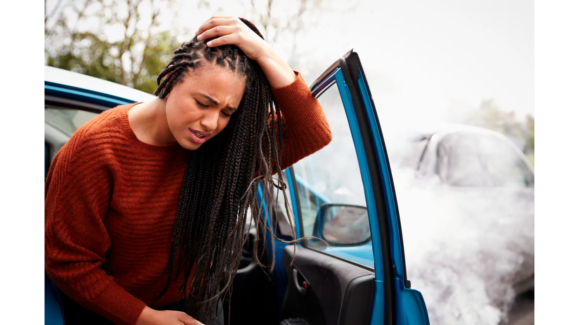 A woman steps out of a car, wincing in pain as she clutches her head.
