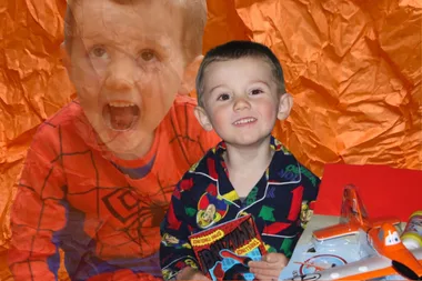 A collage of William Tyrrell against a dark orange background with wrinkled texture. The image on the left is of William wearing a Spider-Man costume. The second image is of him wearing pyjamas and with toys displayed in front of him.