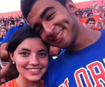 a young couple smiling for the camera he is wearing a blue shirt