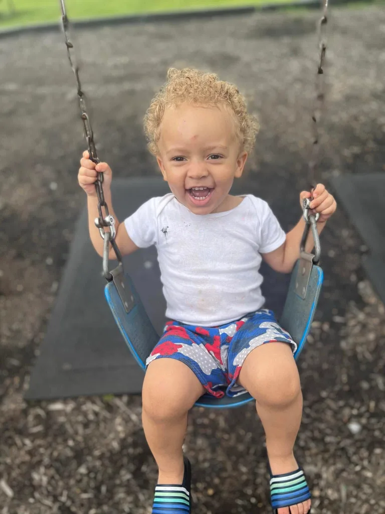Kristian smiling on the swing