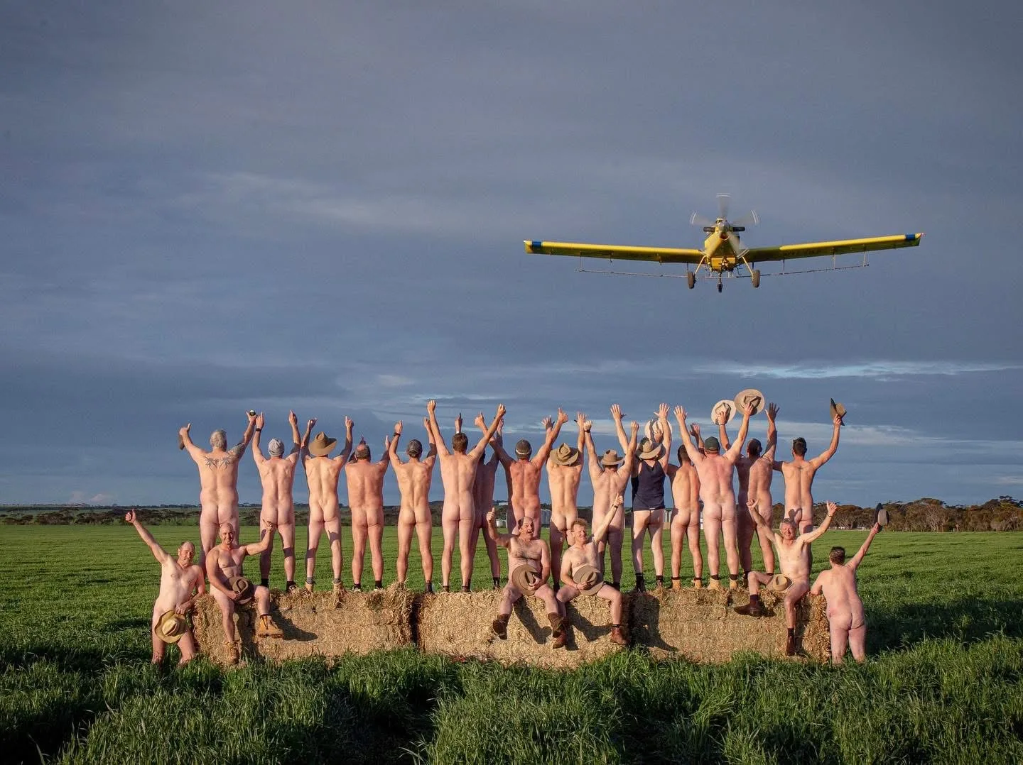 Farmers from Maitland South Australia in the nude. There's a dozen or so posing for the camera outside in a paddock.