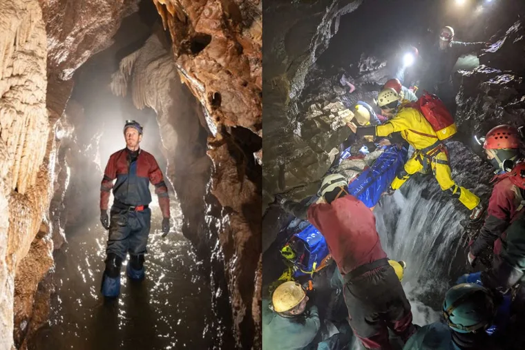man in cave with head torch on and men in waterproofs staging a cave rescue in red and yellow carrying someone in blue.