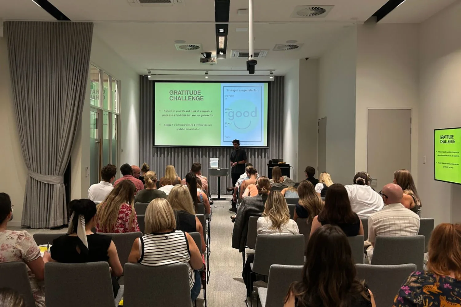 Back view of people seated in rows of chairs at a seminar