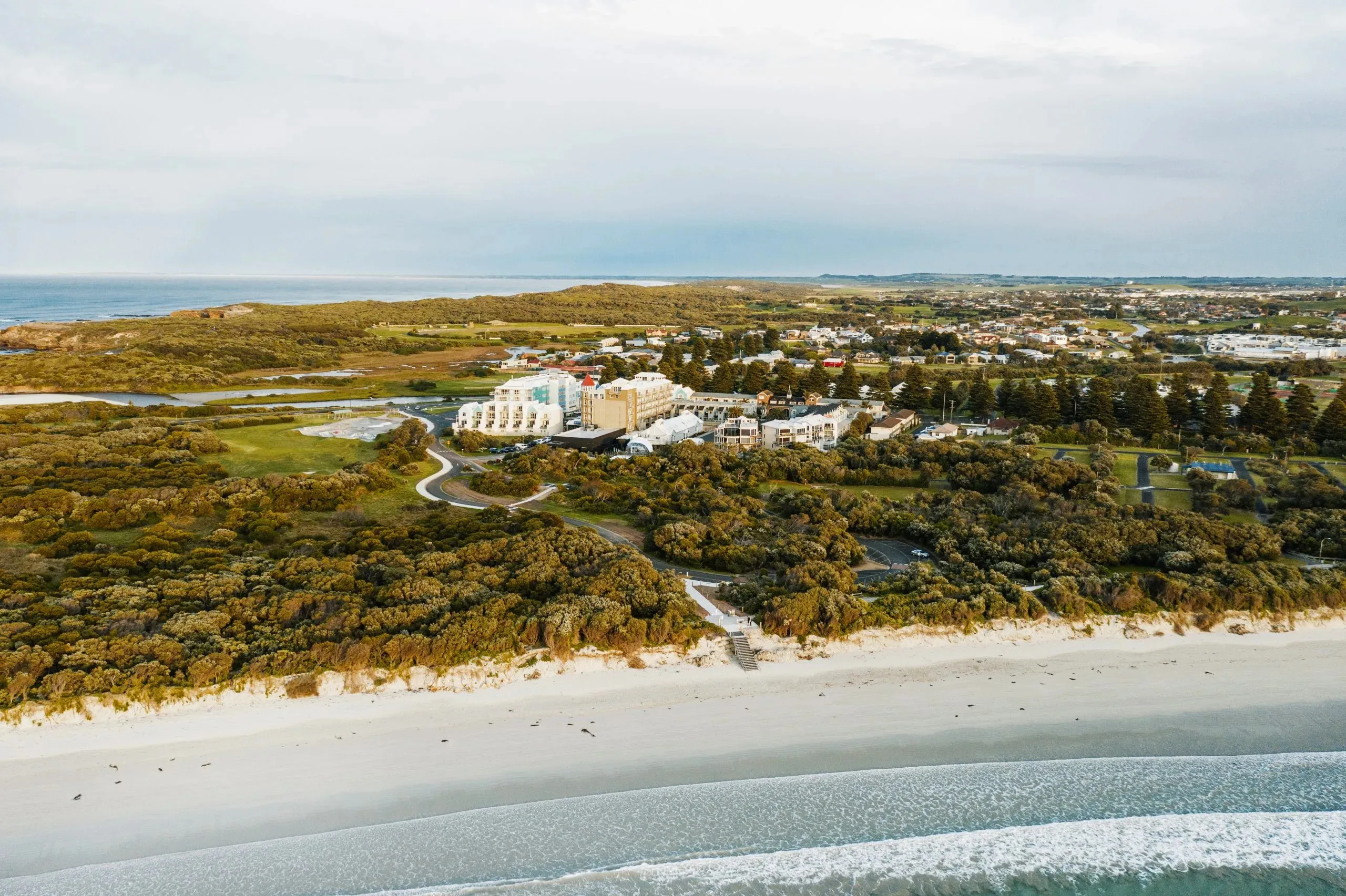 An aerial image of a hotel and hot springs near the beach 