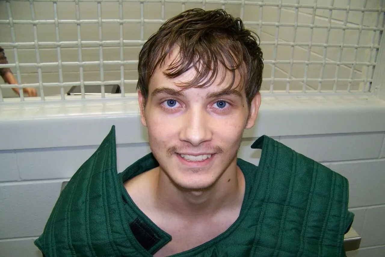 man in jail cell in green outfit 