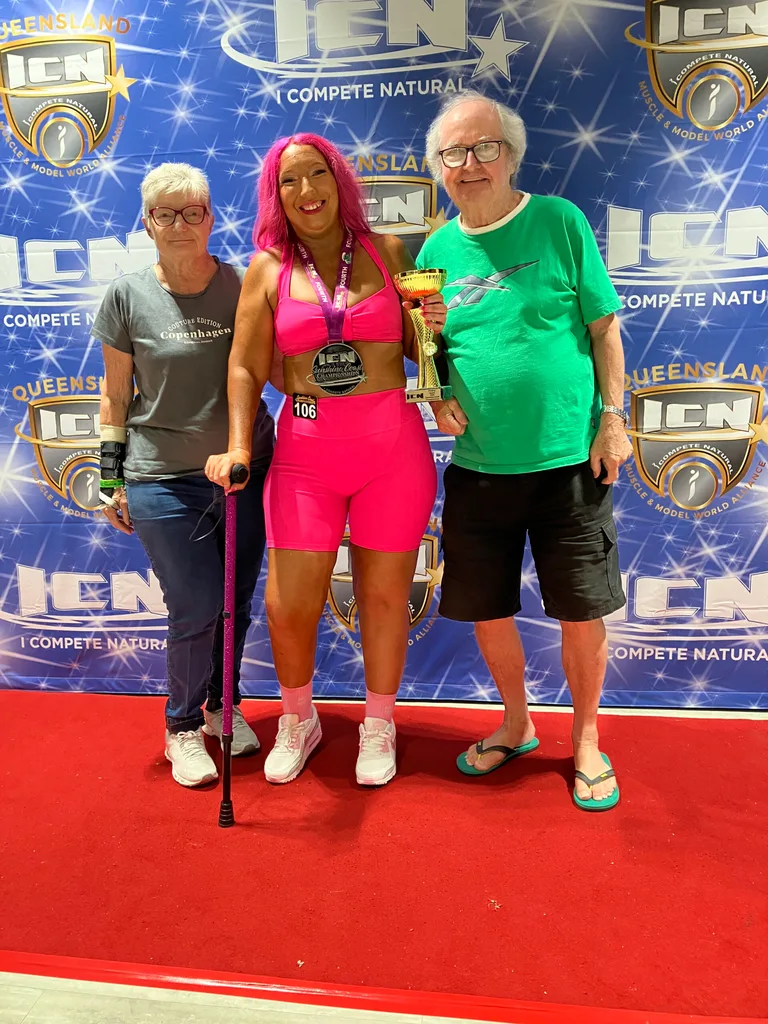 Rebecca in all pink with her family at a bodybuilding event that she competed in being disabled