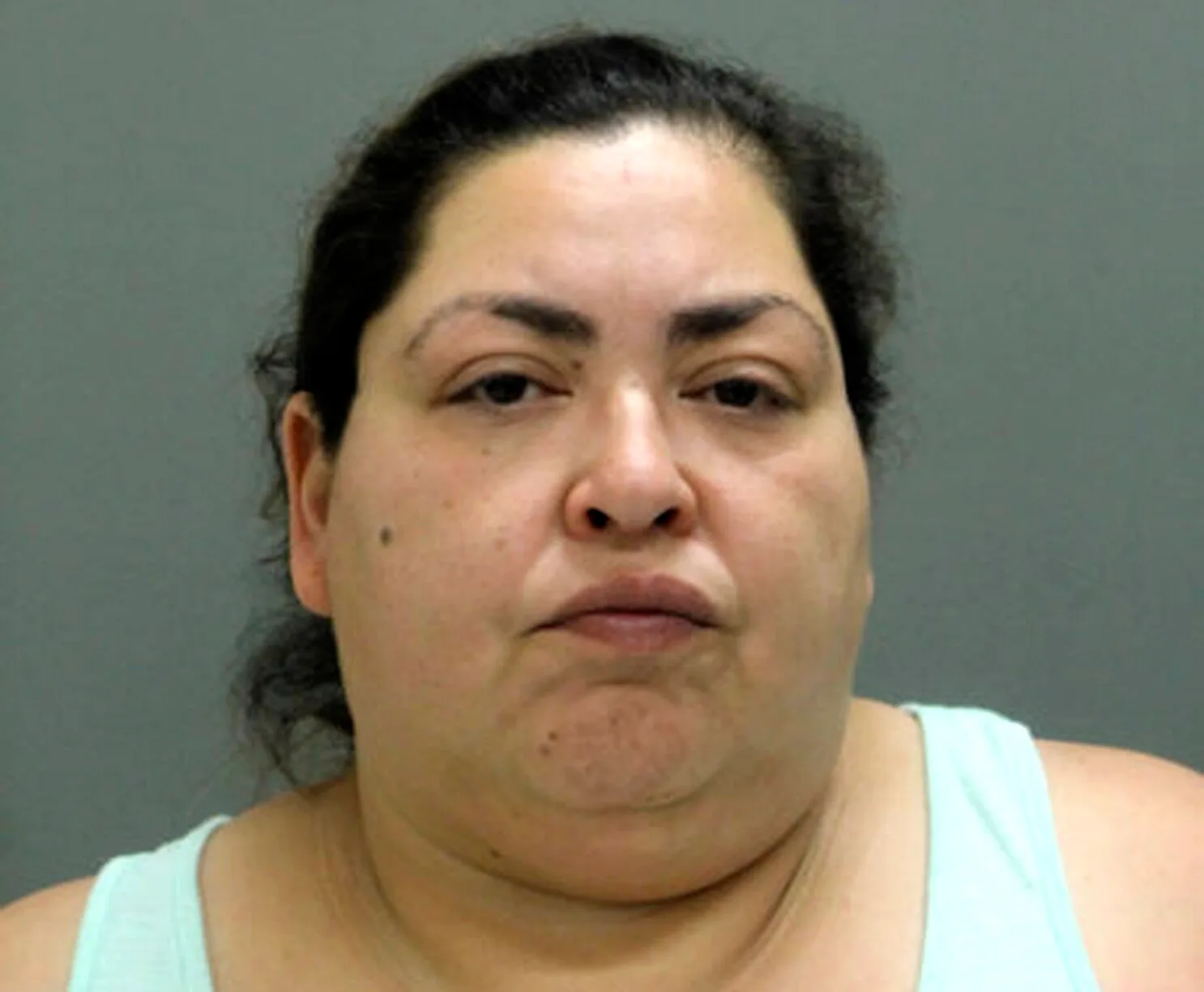police mugshot of woman with dark hair and blue shirt