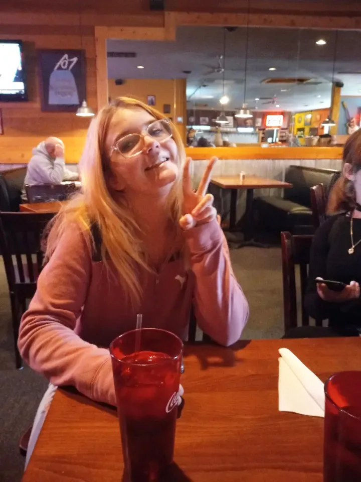 Valarie Tindall smiling, doing the 'peace' sign