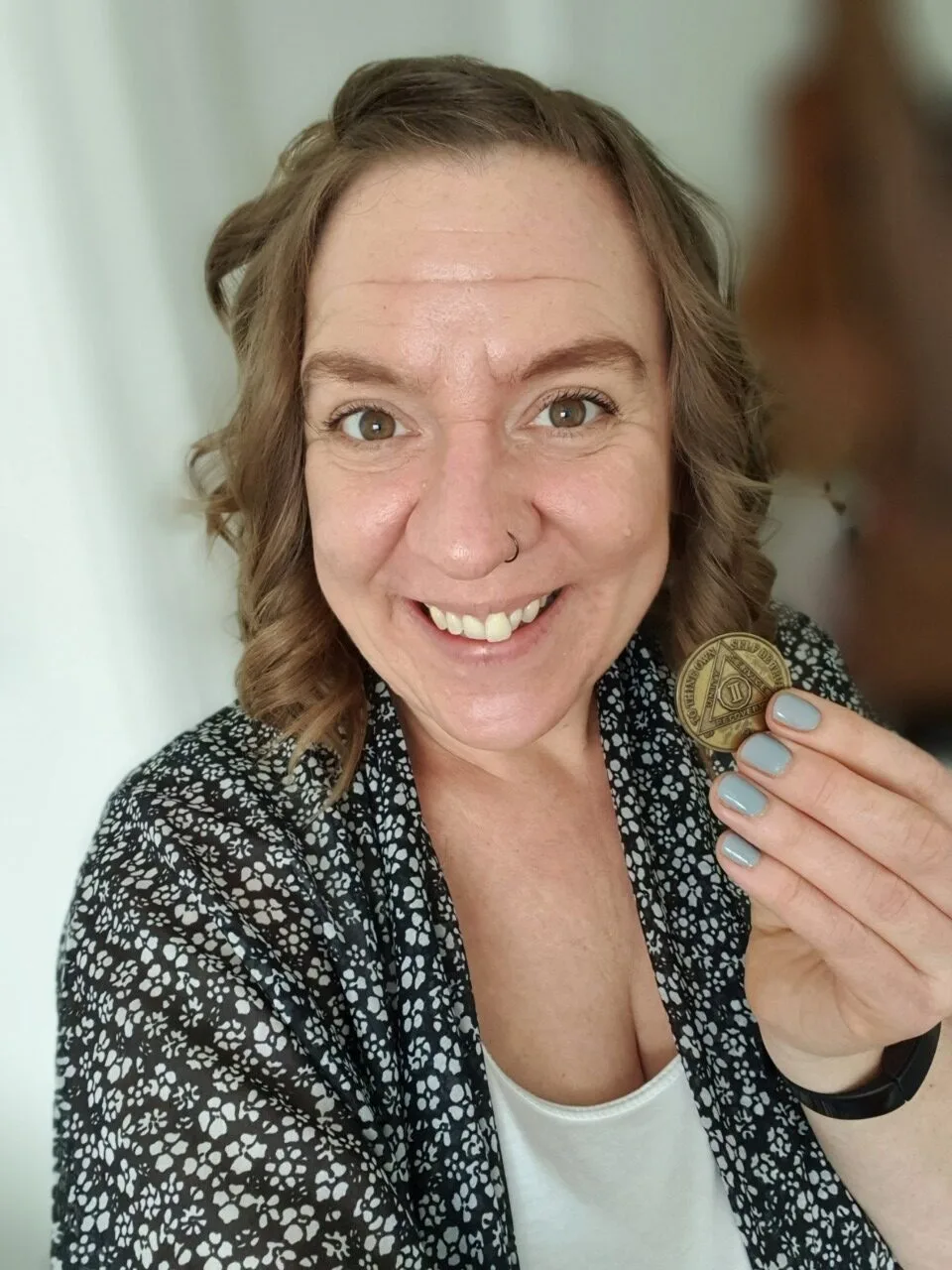 Woman smiling with gold medal in her hand.