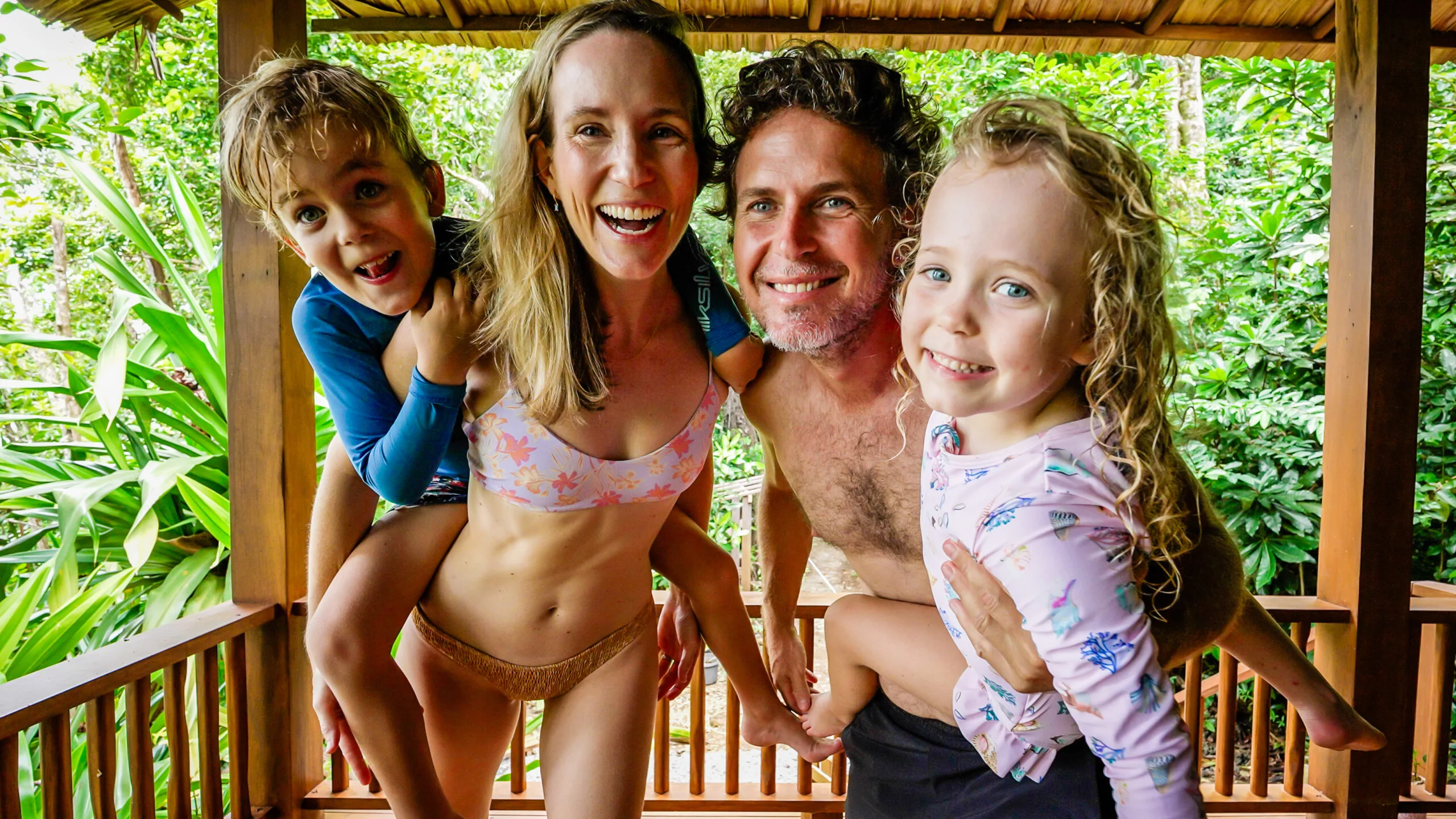 man, woman, son and daughter on balcony smiling at camera.