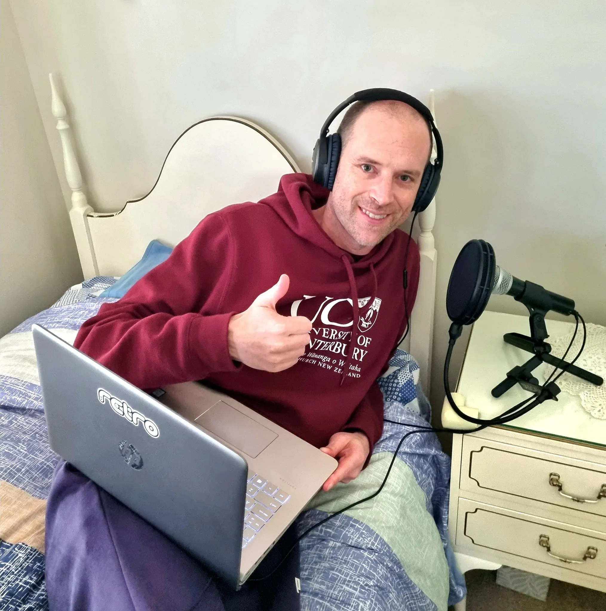 Bradley Simmonds recording a radio show 80s and 90s retro music from his bed