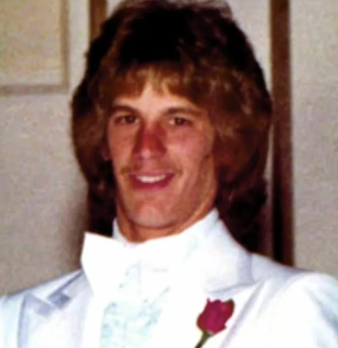 man in white suit with red rose 