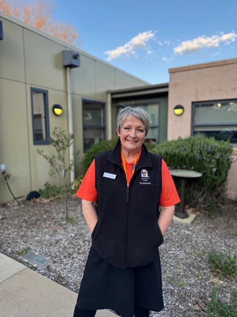 woman in black and orange RMHC outfit outside smiling at the camera