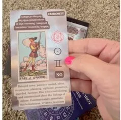 Woman's hand holding a Tarot crad