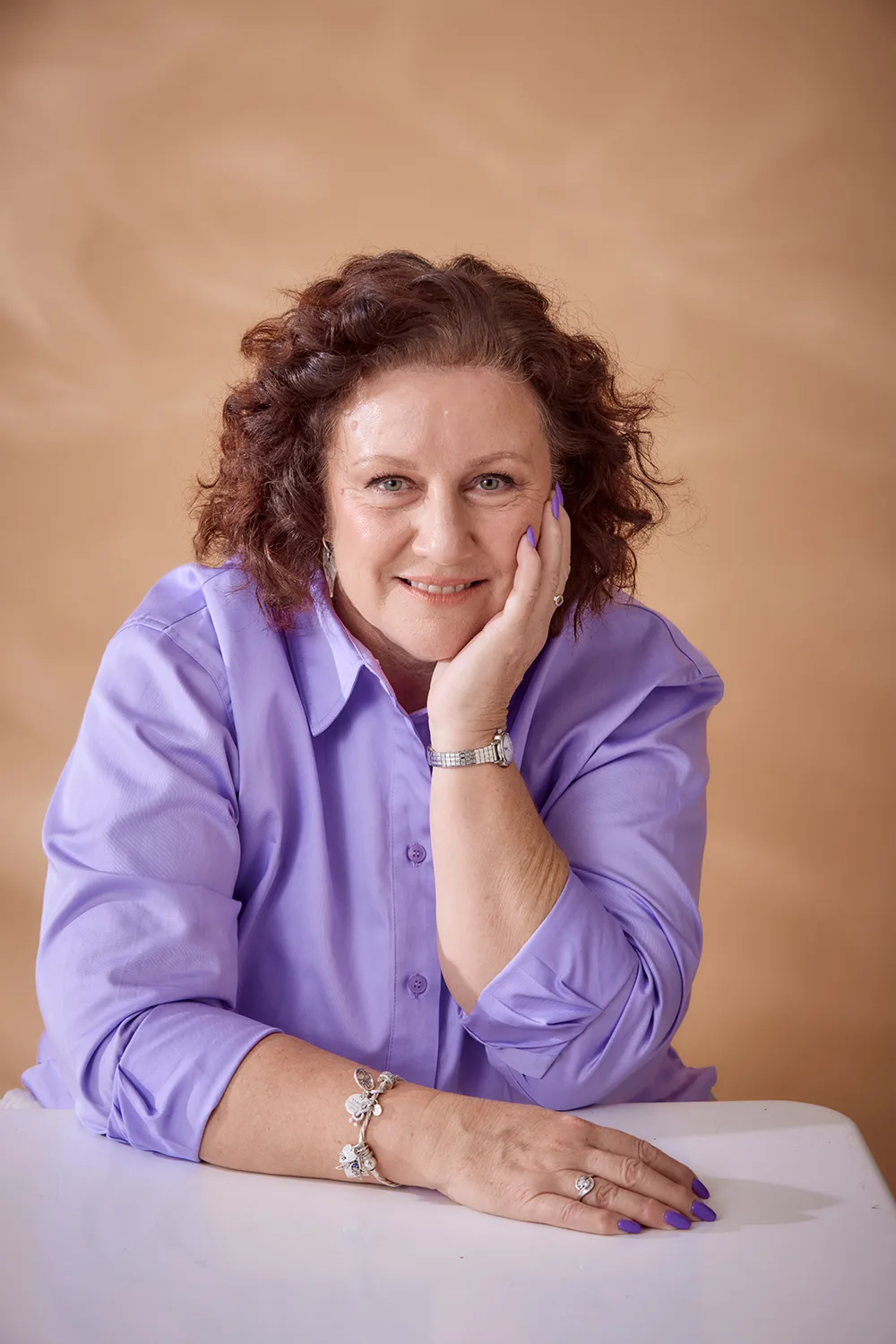 woman with brown hair in purple shirt. 