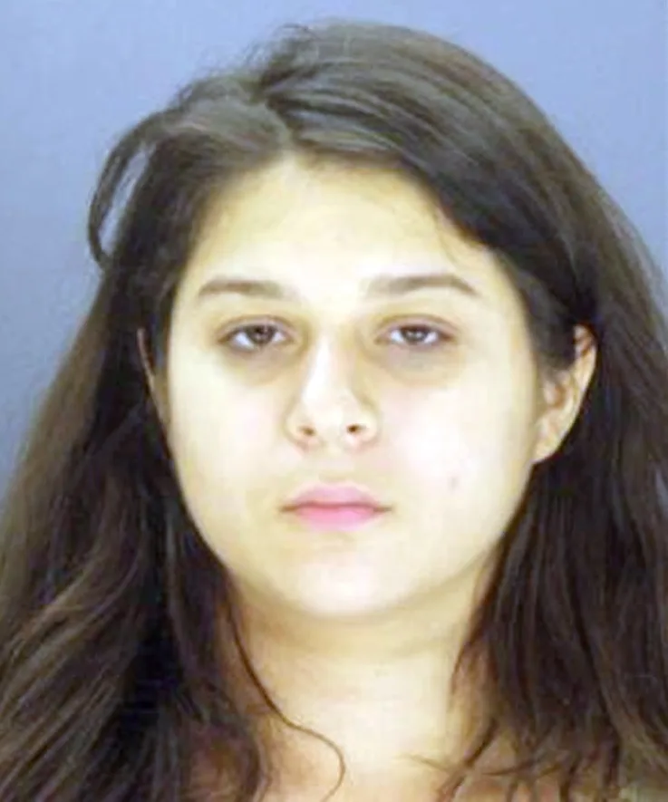 woman with dark hair and pale skin mughshot