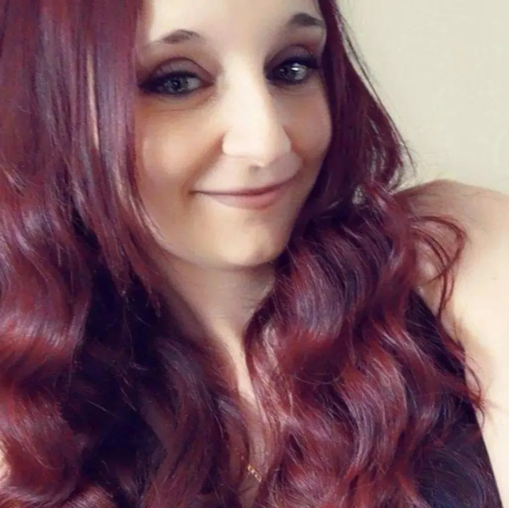 Woman with red hair smiling at camera.