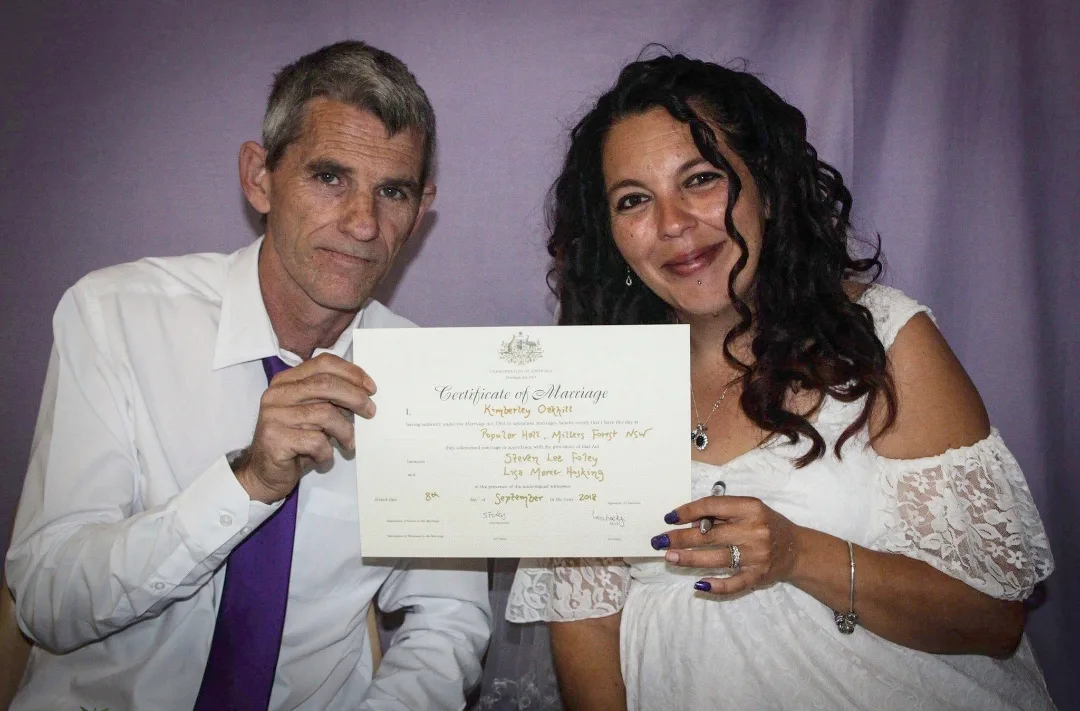 bride and groom holding a wedding certificate