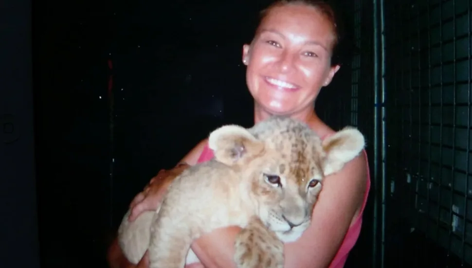 WOMAN holding a tiger cub.