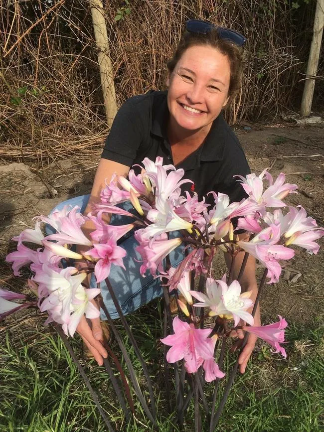 woman smiling holidng coloured flowers