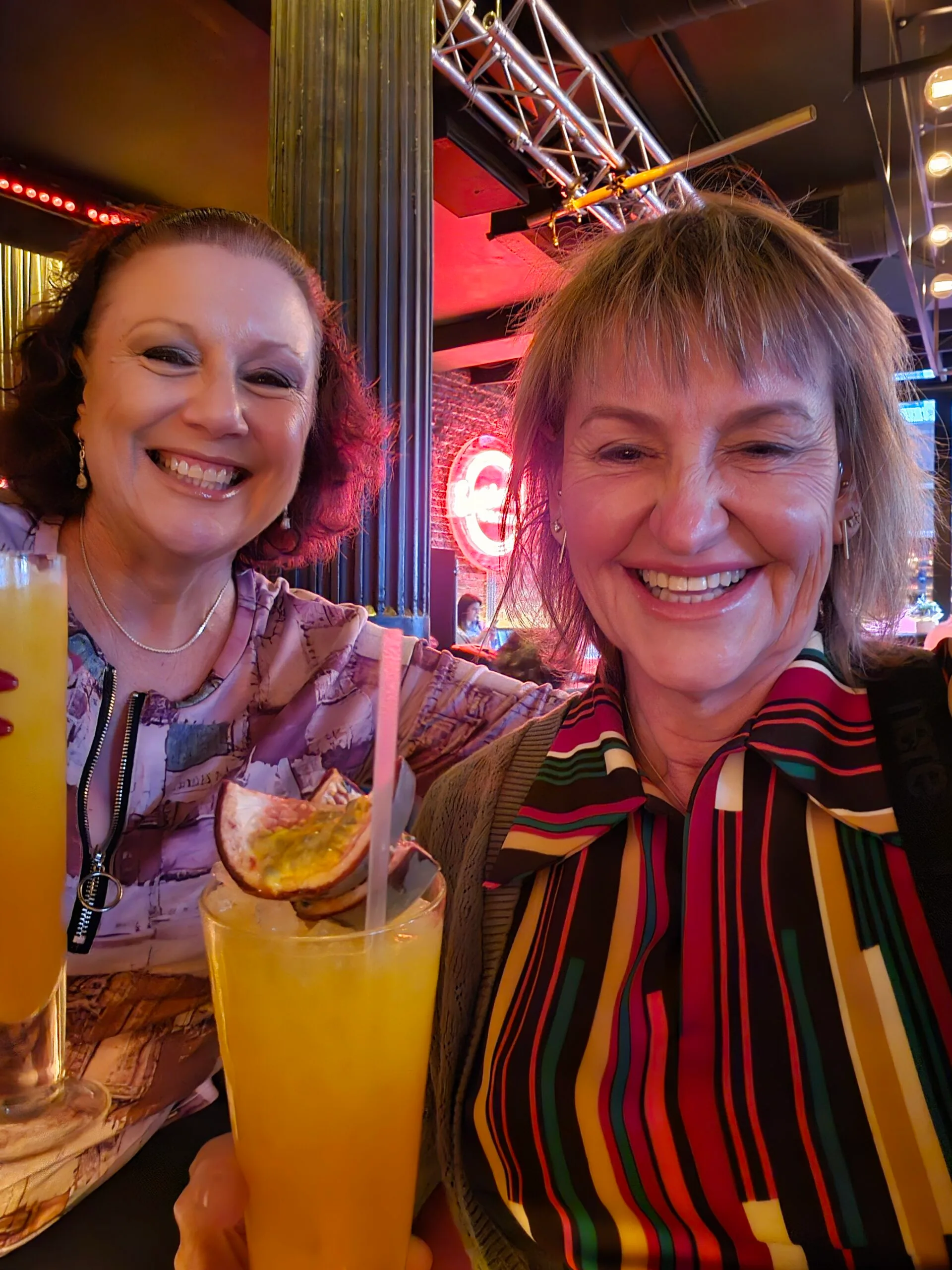 two women at a bar drinking passionfruit drinks