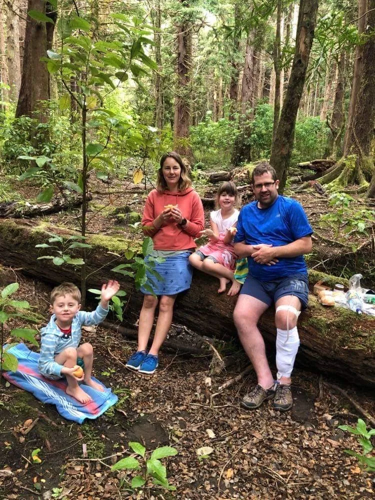family of four having a picnic in the forest