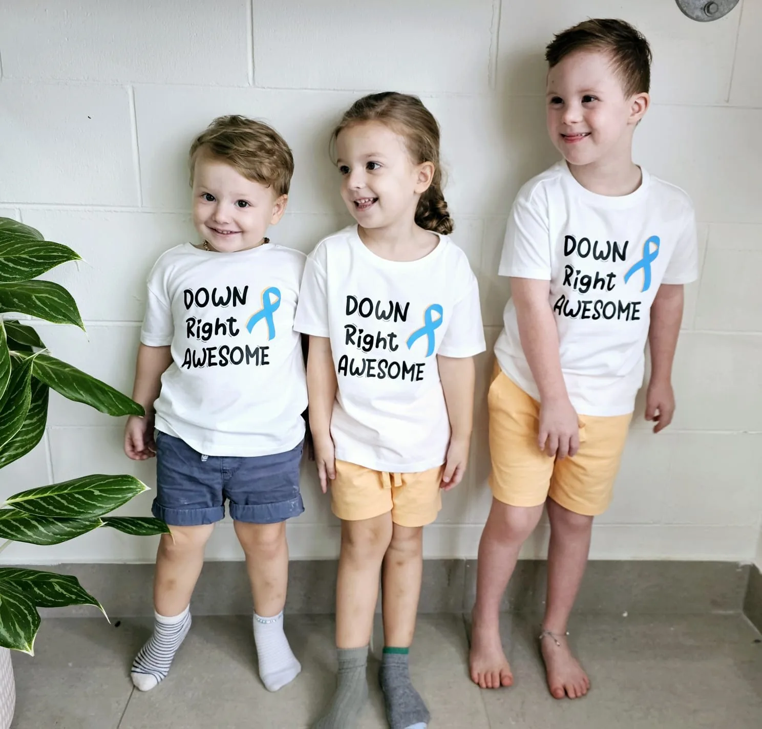 three children wearing shirts that read 'down right awesome'