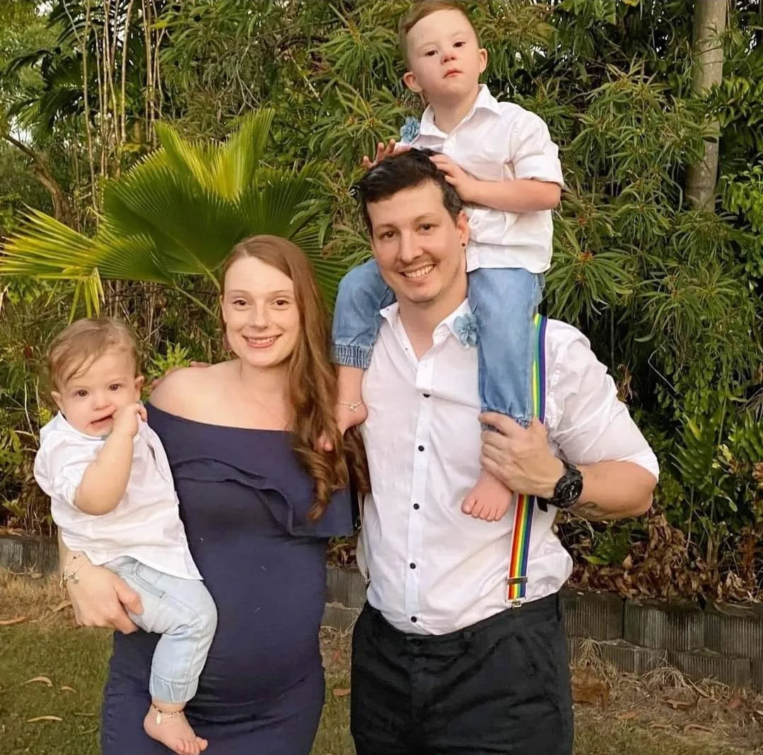 a family photo outside, a young boy in on a mans shoulders