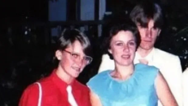 two women, one in red, one in blue in a grainy photo from the 80s