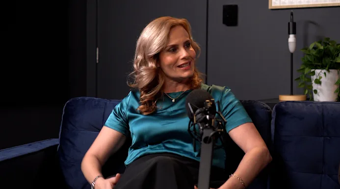 Woman in green top sits in front of microphone