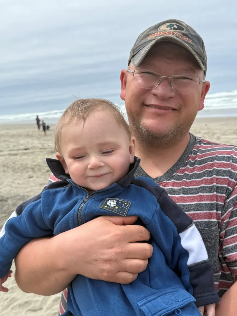 Smiling man holding a baby
