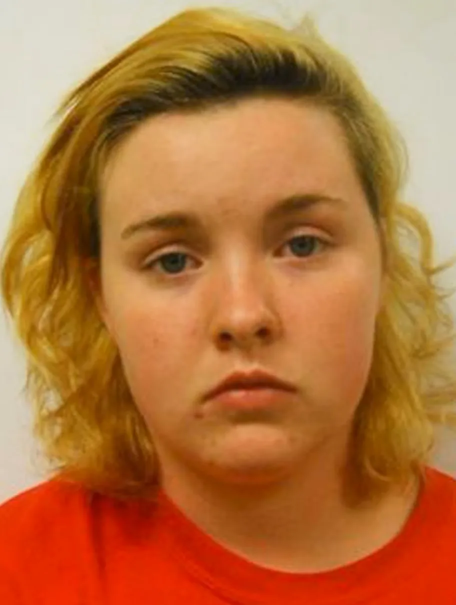 girl mugshot wearing red shirt and curly red hair