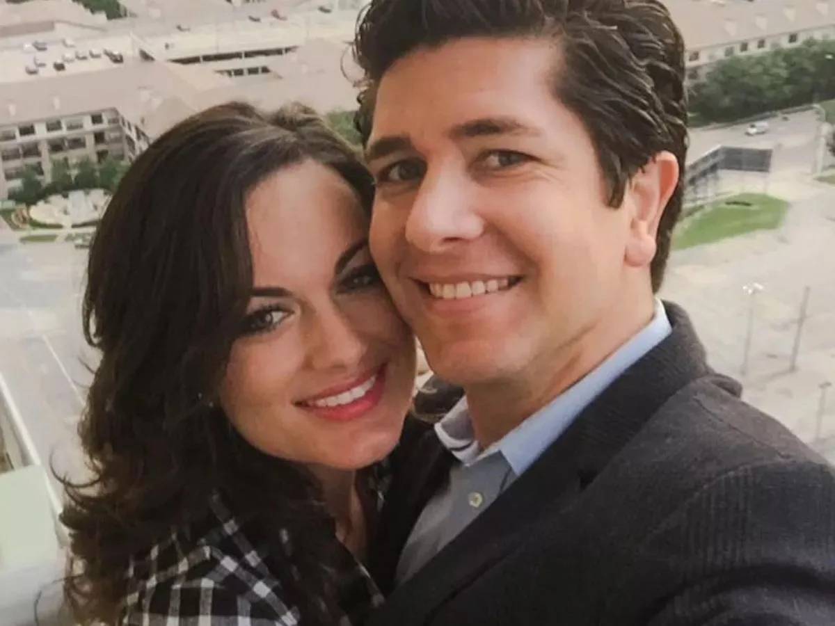 man and woman with dark hair smilng at the camera he is wearing a blazer and shirt 