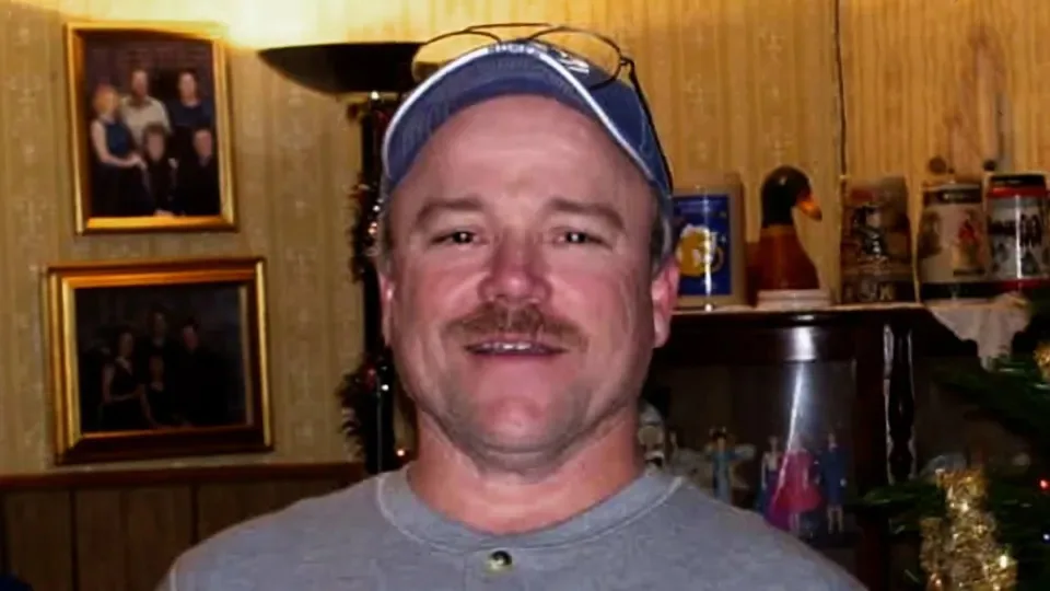 man in wooden home wearing cap 