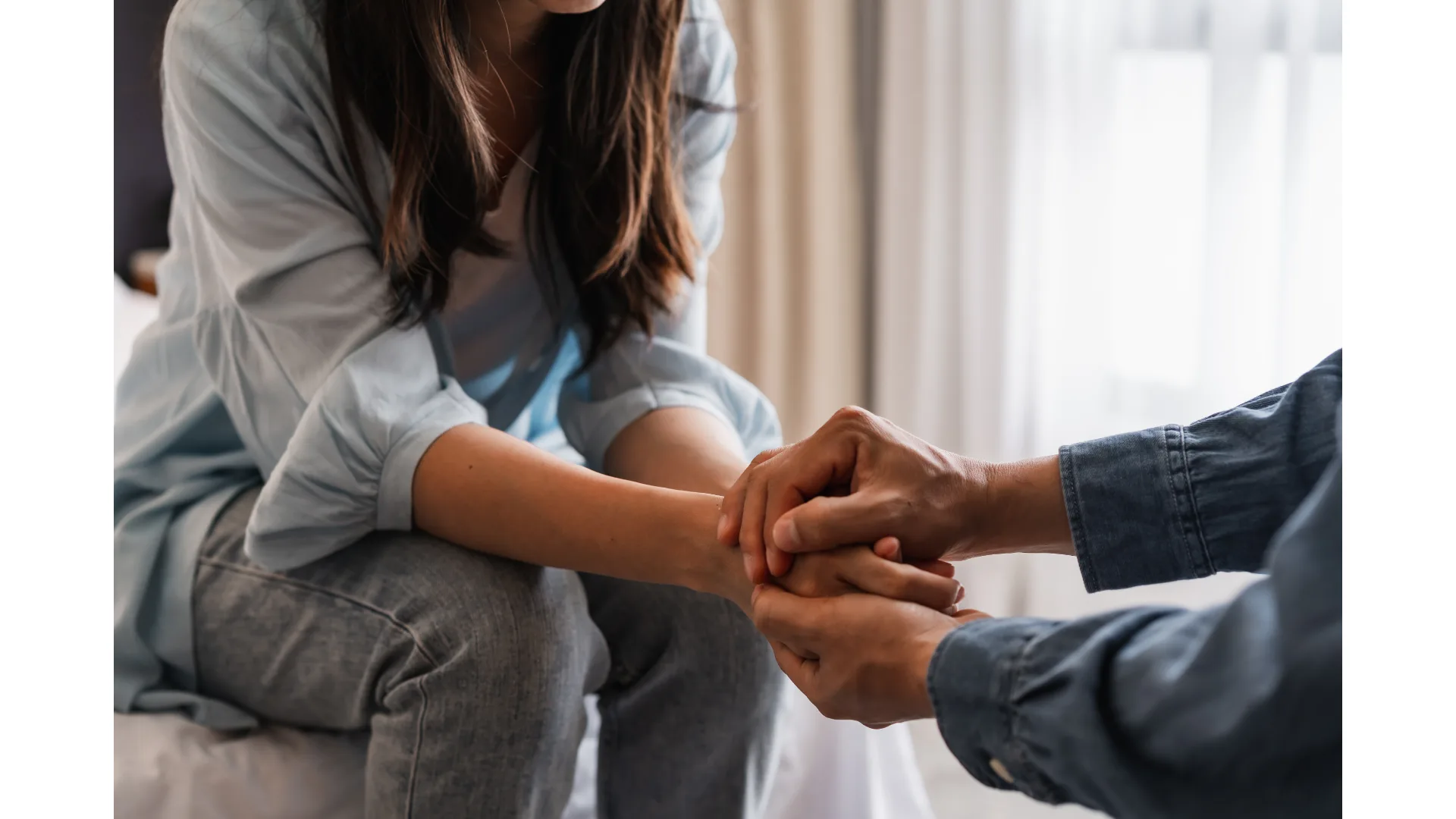 Two people join hands.