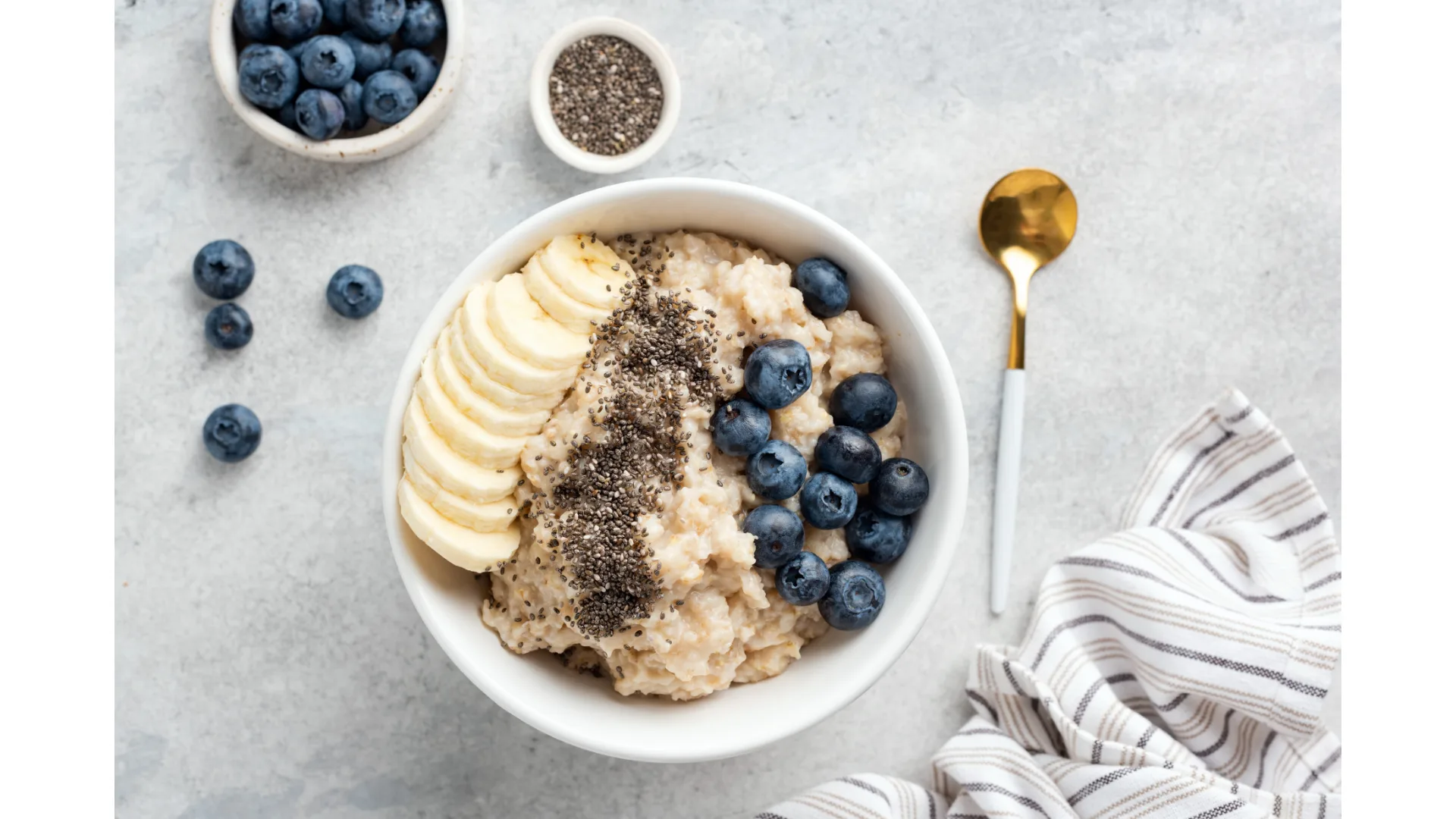 A bowl of porridge with banana and blueberries.