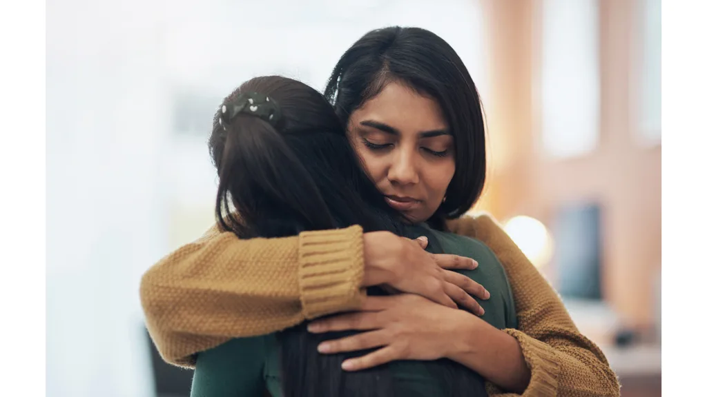 Two women share a heartfelt hug.